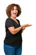 © Krakenimages.com - Beautiful middle ager senior woman over isolated background Pointing to the side with hand and open palm, presenting ad smiling happy and confident