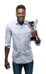 Poster - Young african american man holding trophy scared in shock with a surprise face, afraid and excited with fear expression