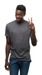 Canvas Print - Young african american man wearing grey t-shirt showing and pointing up with fingers number two while smiling confident and happy.