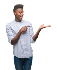 Canvas Print - Young african american man over isolated background amazed and smiling to the camera while presenting with hand and pointing with finger.