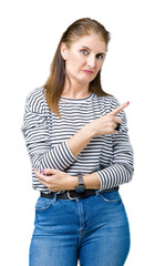 Wall Mural - Middle age mature beautiful woman wearing stripes winter sweater over isolated background Pointing with hand finger to the side showing advertisement, serious and calm face