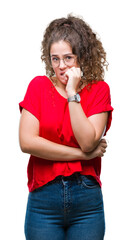 Poster - Beautiful brunette curly hair young girl wearing glasses over isolated background looking stressed and nervous with hands on mouth biting nails. Anxiety problem.