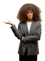 Poster - African american business woman wearing glasses smiling cheerful presenting and pointing with palm of hand looking at the camera.