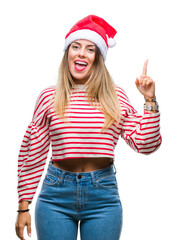 Sticker - Young beautiful woman wearing christmas hat over isolated background pointing finger up with successful idea. Exited and happy. Number one.