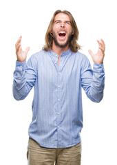 Canvas Print - Young handsome man with long hair over isolated background crazy and mad shouting and yelling with aggressive expression and arms raised. Frustration concept.