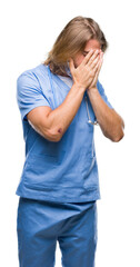 Wall Mural - Young handsome doctor man with long hair over isolated background with sad expression covering face with hands while crying. Depression concept.