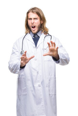 Wall Mural - Young handsome doctor man with long hair over isolated background afraid and terrified with fear expression stop gesture with hands, shouting in shock. Panic concept.