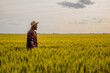 © inesbazdar - Young happy farmer is standing in his growing wheat field.