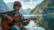 © EEKONG - A teenage boy playing guitar by a lakeside, focused and happy, with the water and mountains in the background