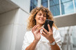 © Miljan Živković - Portrait of adult woman stand in front business build use mobile phone