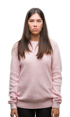 Sticker - Young beautiful hispanic woman wearing a sweater with serious expression on face. Simple and natural looking at the camera.