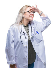 Poster - Young blonde doctor woman over isolated background very happy and smiling looking far away with hand over head. Searching concept.