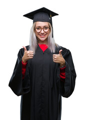 Sticker - Young blonde woman wearing graduate uniform over isolated background approving doing positive gesture with hand, thumbs up smiling and happy for success. Looking at the camera, winner gesture.