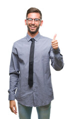 Canvas Print - Young handsome business man over isolated background doing happy thumbs up gesture with hand. Approving expression looking at the camera with showing success.