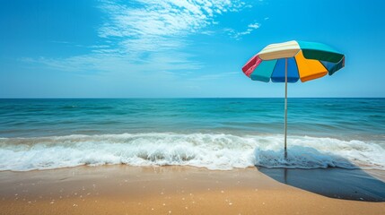 Poster - A serene beach scene featuring gentle waves lapping against the shore and a colorful beach umbrella providing shade