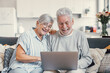 © Daniel - Pretty elderly 70s grey-haired couple resting on couch in living room hold on lap laptop watching movie smiling enjoy free time, older generation and modern wireless technology advanced users concept.