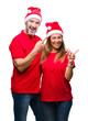 © Krakenimages.com - Middle age hispanic couple wearing christmas hat over isolated background smiling and looking at the camera pointing with two hands and fingers to the side.