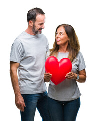 Wall Mural - middle age hispanic casual couple in love holding red heart over isolated background with a confiden