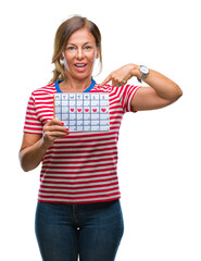 Sticker - Middle age senior hispanic woman holding menstruation calendar over isolated background with surprise face pointing finger to himself