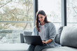 © Daniel - Concentrated millennial girl sit on couch working on laptop browsing internet at home during lazy weekend, focused young woman freelancer busy using computer surfing wireless web shopping online.