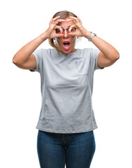 Wall Mural - Middle age senior hispanic woman wearing glasses over isolated background doing ok gesture like binoculars sticking tongue out, eyes looking through fingers. Crazy expression.