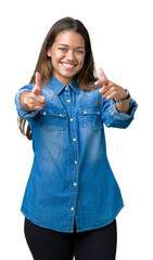 Poster - Young beautiful brunette woman wearing blue denim shirt over isolated background pointing fingers to camera with happy and funny face. Good energy and vibes.