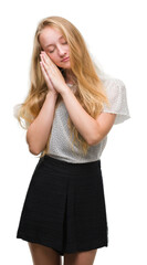 Canvas Print - Blonde teenager woman wearing moles shirt sleeping tired dreaming and posing with hands together while smiling with closed eyes.