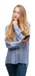 © Krakenimages.com - Blonde teenager woman using smartphone serious face thinking about question, very confused idea