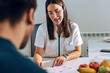 © nenetus - Beautiful young nutritionist woman explaining to her patient the diet he should follow to lose weight in the consultation.