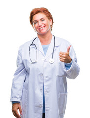 Canvas Print - Senior caucasian doctor woman wearing medical uniform over isolated background doing happy thumbs up gesture with hand. Approving expression looking at the camera with showing success.