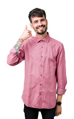 Canvas Print - Young handsome man wearing pink shirt over isolated background smiling doing phone gesture with hand and fingers like talking on the telephone. Communicating concepts.