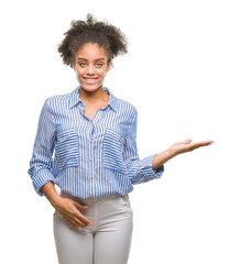 Sticker - Young afro american woman over isolated background smiling cheerful presenting and pointing with palm of hand looking at the camera.