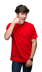 Sticker - Young handsome man wearing red t-shirt over isolated background smiling doing phone gesture with hand and fingers like talking on the telephone. Communicating concepts.