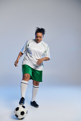 Wall Mural - A woman in a white jersey and green shorts dribbles a soccer ball.