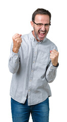 Canvas Print - Handsome middle age elegant senior man wearing glasses over isolated background very happy and excited doing winner gesture with arms raised, smiling and screaming for success. Celebration concept.