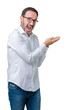 © Krakenimages.com - Handsome middle age elegant senior business man wearing glasses over isolated background Pointing to the side with hand and open palm, presenting ad smiling happy and confident