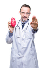 Canvas Print - Middle age senior hoary cardiologist doctor man holding heart over isolated background with open hand doing stop sign with serious and confident expression, defense gesture