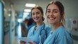 © hisilly - Cheerful Nurses Reviewing Documents in Hospital Corridor