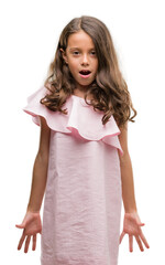 Sticker - Brunette hispanic girl wearing pink dress afraid and shocked with surprise expression, fear and excited face.