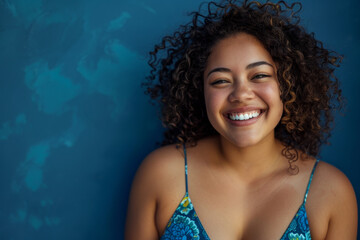 Wall Mural - A woman with curly hair is smiling and wearing a blue tank top
