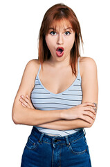 Poster - Redhead young woman with arms crossed gesture afraid and shocked with surprise and amazed expression, fear and excited face.