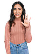 © Krakenimages.com - Hispanic teenager girl with dental braces wearing casual clothes showing and pointing up with fingers number five while smiling confident and happy.