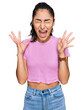 © Krakenimages.com - Hispanic teenager girl with dental braces wearing casual clothes celebrating mad and crazy for success with arms raised and closed eyes screaming excited. winner concept