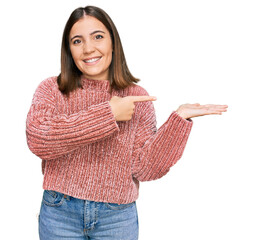 Wall Mural - Young beautiful woman wearing casual clothes amazed and smiling to the camera while presenting with hand and pointing with finger.