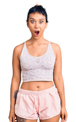 Poster - Young woman wearing sportswear scared and amazed with open mouth for surprise, disbelief face