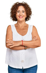 Canvas Print - Beautiful middle age mature woman wearing casual white shirt happy face smiling with crossed arms looking at the camera. positive person.