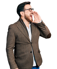 Wall Mural - Young hispanic man wearing business jacket and glasses shouting and screaming loud to side with hand on mouth. communication concept.