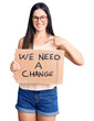 © Krakenimages.com - Young beautiful caucasian woman holding we need a change banner pointing finger to one self smiling happy and proud