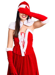 Sticker - Young beautiful caucasian woman wearing santa claus costume smiling and laughing with hand on face covering eyes for surprise. blind concept.