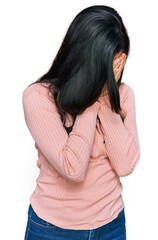 Wall Mural - Young hispanic woman wearing casual clothes with sad expression covering face with hands while crying. depression concept.